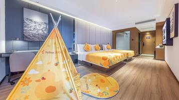 Quarto de hotel com cama, escrivaninha, cadeira, janela e porta.