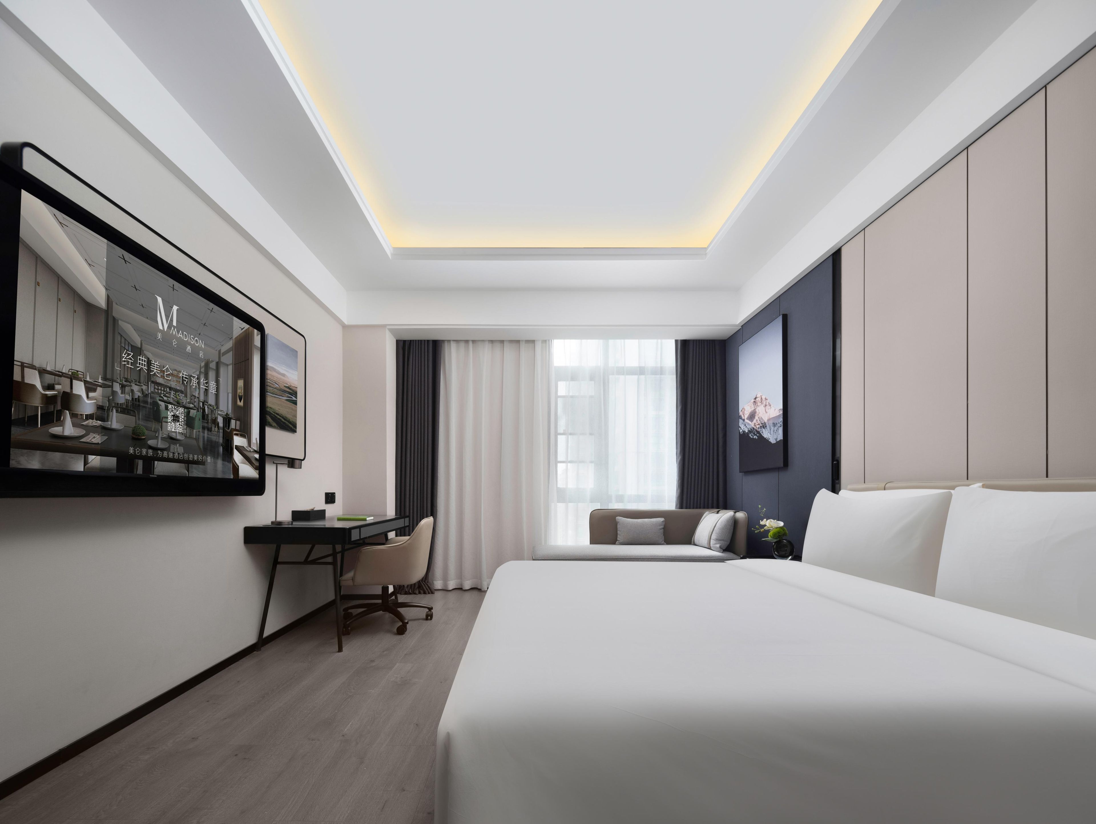 A modern hotel room with a large bed, a desk with a chair, a large mirror, and a window with curtains.