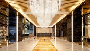 A spacious lobby with a central reception desk, a chandelier, and marble flooring. - Meilun Hotel Xian Qujiang Convention Center Mixc (Xi'an)