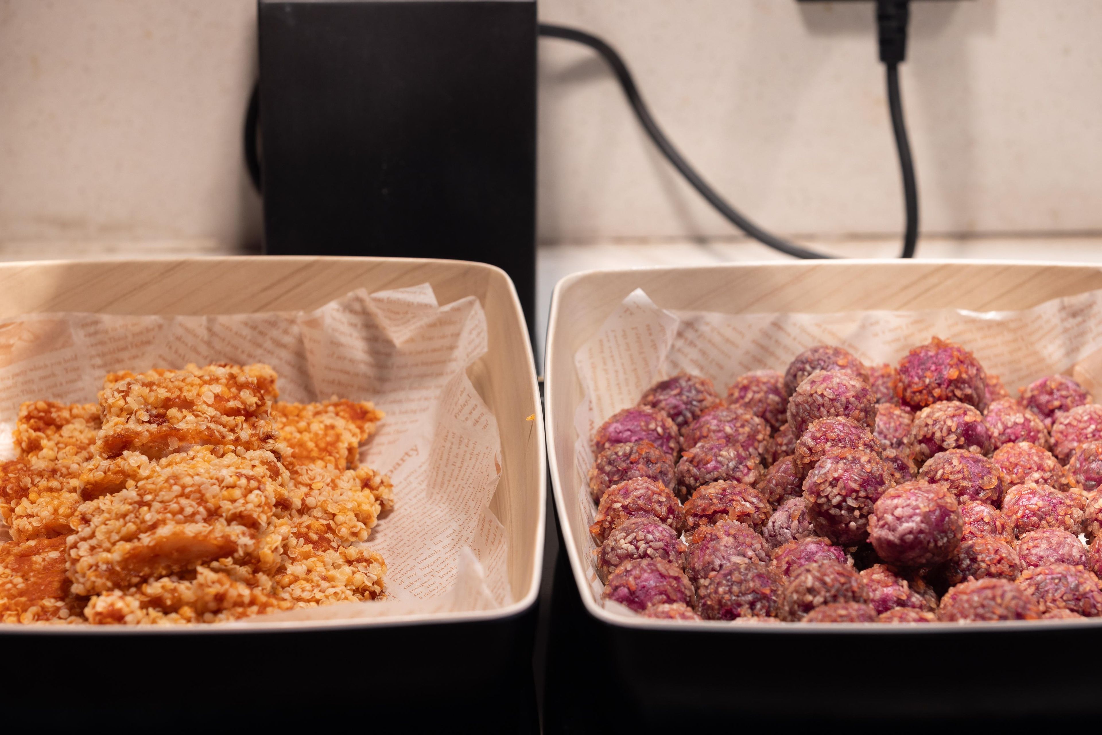 Two trays of food items on a table.