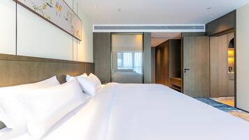 A hotel room with a large bed, a wardrobe, a mirror, and a painting on the wall.