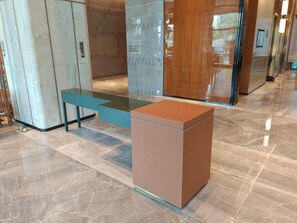 Eine moderne Lobby mit Marmorboden, einem Glastisch und einer Holzbank.