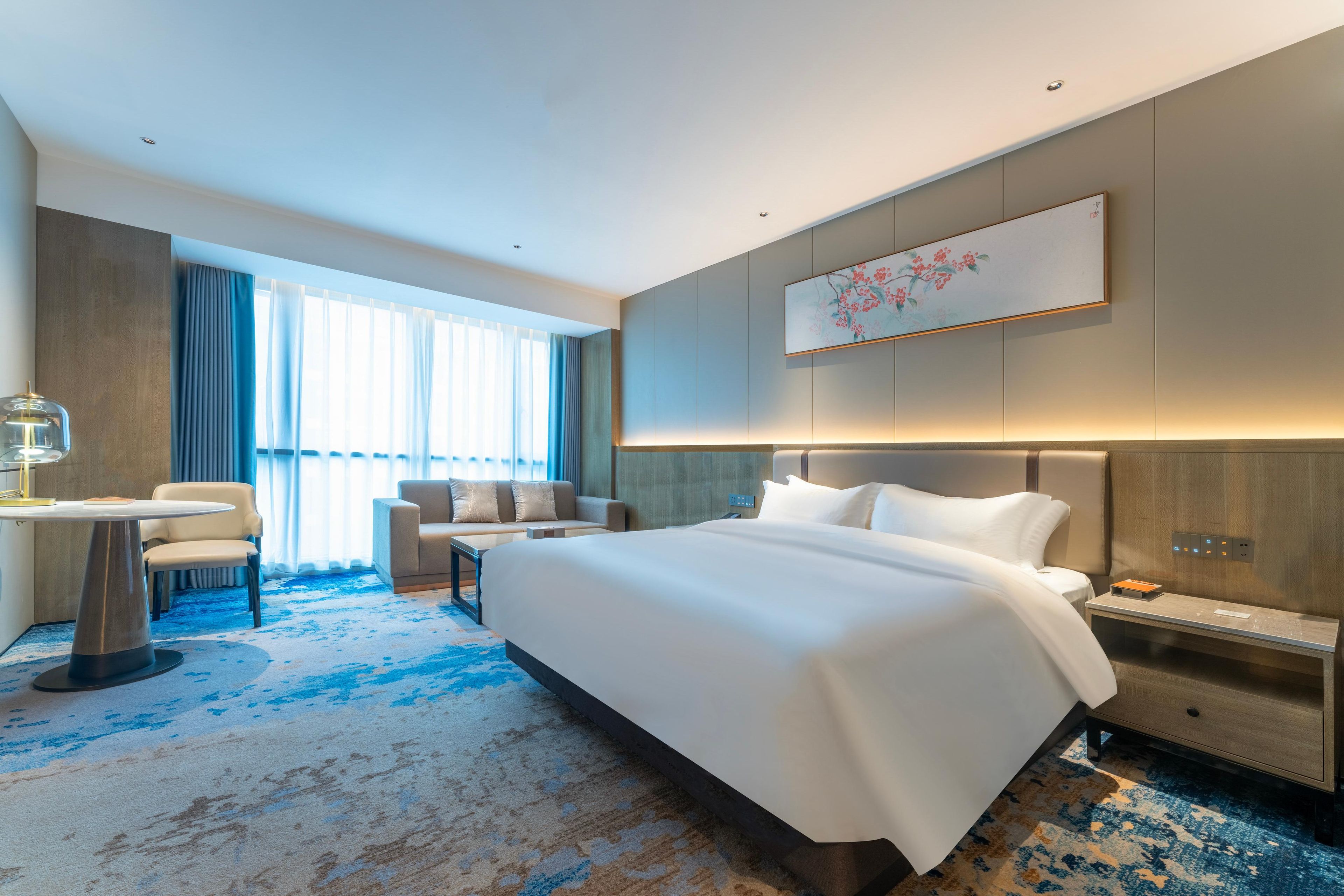 Une chambre d’hôtel moderne dotée d’un grand lit, d’un bureau et d’un coin salon.