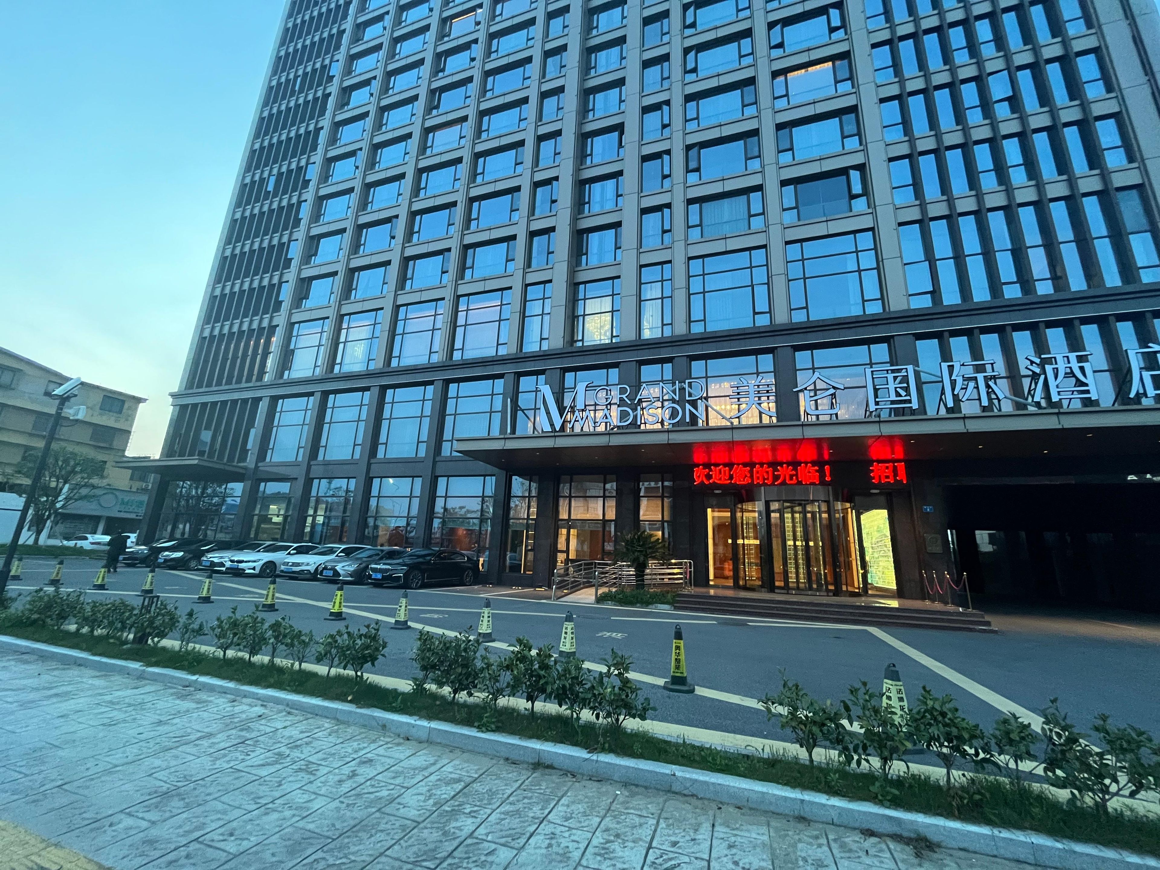 Un hôtel moderne, avec une grande façade en verre et une entrée imposante.
