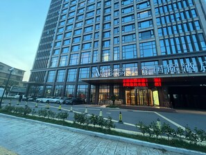 Een modern hotelgebouw met een grote glazen gevel en een opvallende entree.
