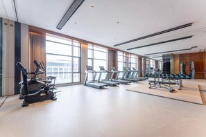 Et moderne fitnesscenter med løbebånd, crosstrainere og vægte.