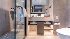 Ein modernes Badezimmer mit Duschkabine aus Glas, Marmorwaschtisch und Toilette.
