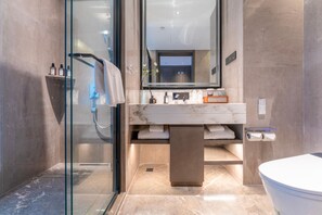 Un bagno moderno con box doccia in vetro, lavabo in marmo e servizi igienici.