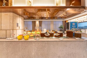A buffet setup with various food items and bowls on a marble counter. - Grand Madison Hotel Quzhou High-speed Railway Sta (Quzhou)