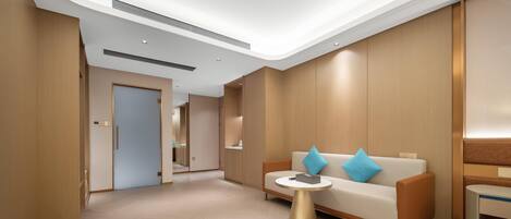 Un moderno vestíbulo de hotel con piso de madera, un sofá con cojines azules, una mesa dorada y un mostrador de recepción de madera.