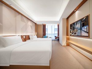 A hotel room with two beds, a seating area with a table and chairs, a large window with curtains, and a wall-mounted TV. - Madison Hotel Wuxi Luocheng (Wuxi)