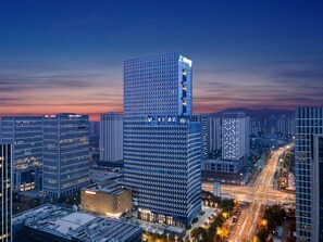 A high-rise hotel with a modern glass facade, multiple floors, and a prominent signage at the top. - Madison Hotel Wuxi Luocheng (Wuxi)