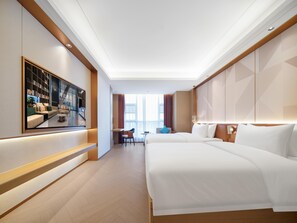 Une chambre d’hôtel avec un grand lit, un bureau, une chaise et un téléviseur fixé au mur.