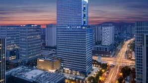 A high-rise hotel with a modern glass facade, multiple floors, and a prominent signage at the top.