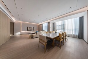 A modern conference room with a large table, several chairs, a sofa, and a large window with curtains. - Grand Madison Hotel Xiangyang Hexin Outlets (Xiangyang)