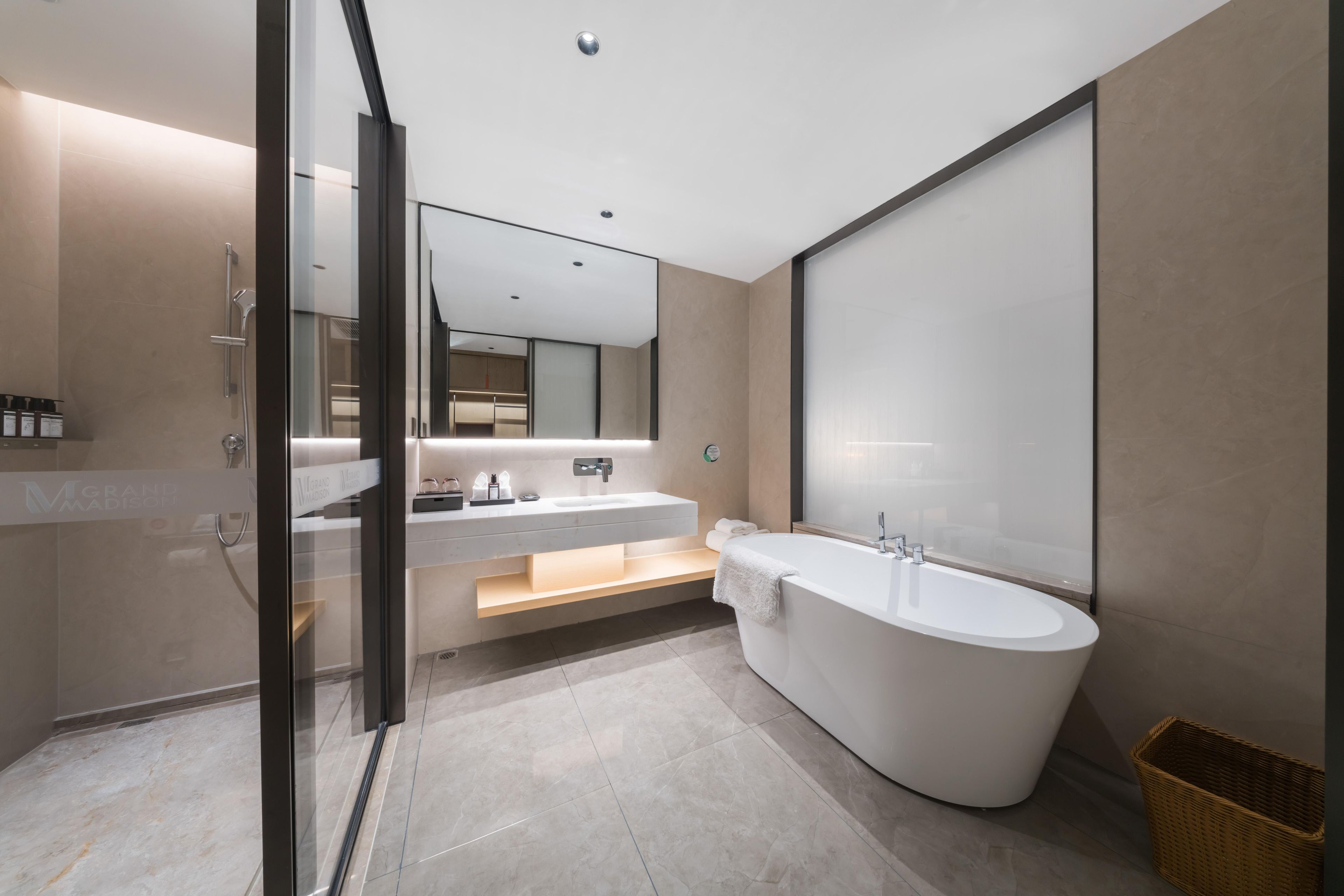 A modern bathroom with a freestanding bathtub, a glass shower enclosure, and a large mirror.