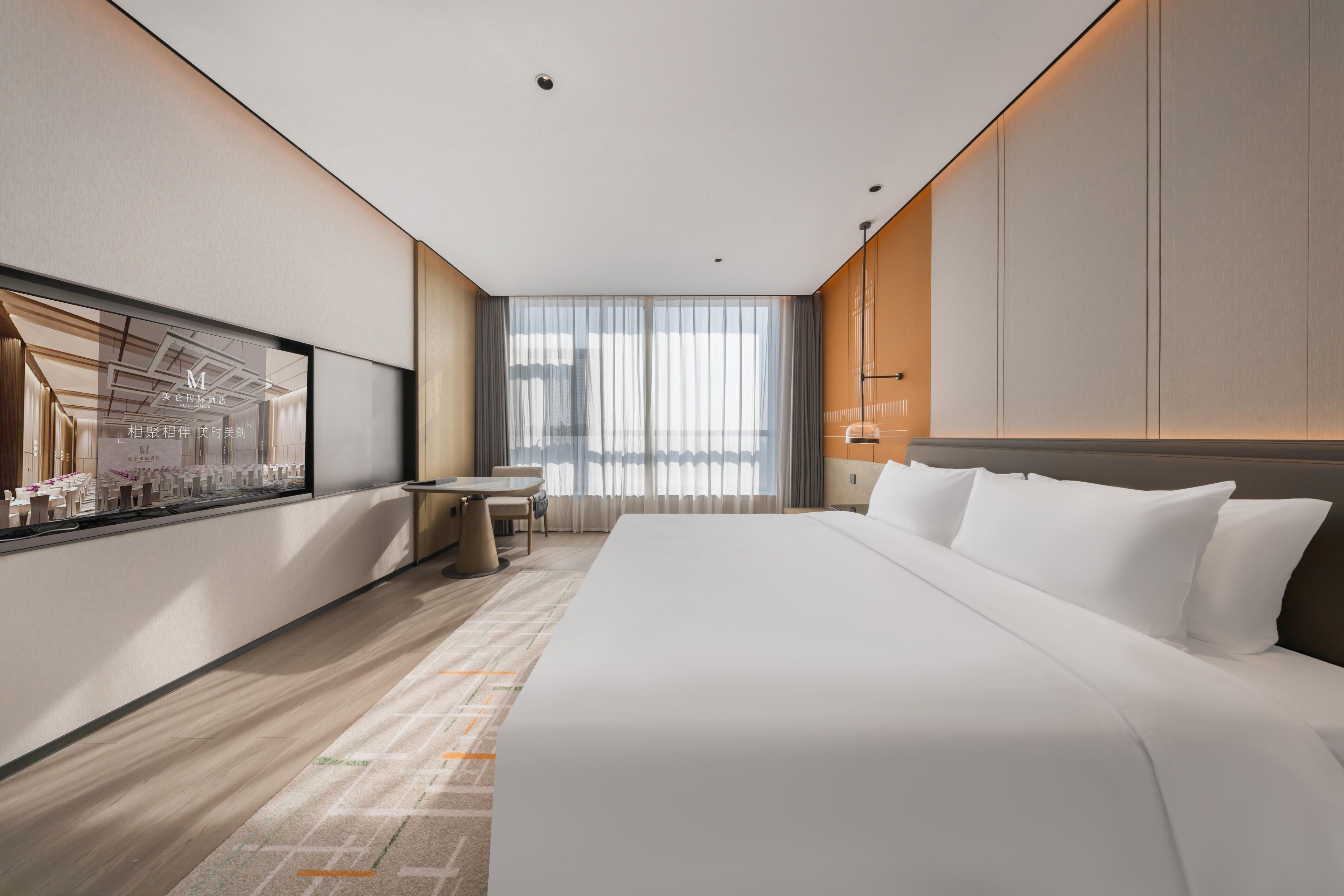 A modern hotel room with a large bed, a desk, and a window with curtains.