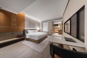 A modern hotel room with a large bed, a desk, and a TV. - Grand Madison Hotel Xiangyang Hexin Outlets (Xiangyang)