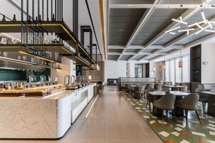 Un comedor moderno con una barra larga, diversas disposiciones de asientos y un techo decorativo.