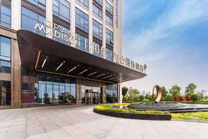 Un edificio moderno con un amplio frente de cristal y un cartel que dice 'GRAND MADISON'.