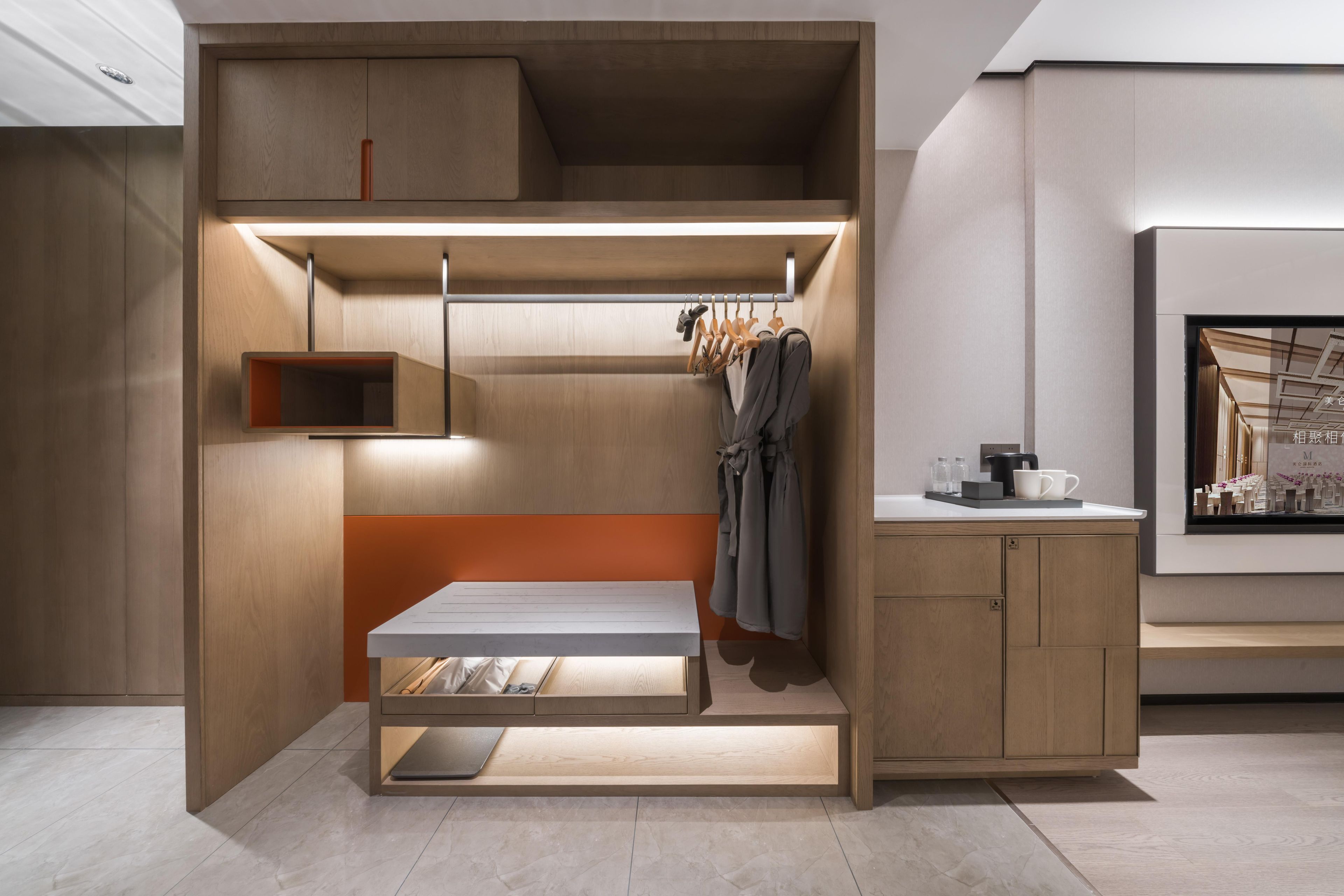 Una habitación moderna y funcional, con cama empotrada, mesitas de noche y una pequeña zona de estar.