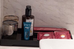 A tray with a bottle of soap, a blue container, and red bags. - Madison Hotel Jinan Suncun Chunhui Road (Jinan)