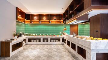 Une cuisine moderne dotée d’un îlot central, d’étagères intégrées et d’un revêtement mural vert.
