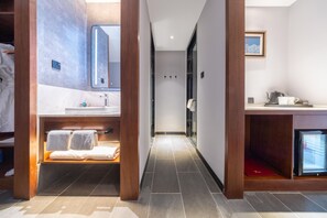 A modern bathroom with a vanity, a mirror, a shower, and a small refrigerator. - Madison Hotel Jinan Suncun Chunhui Road (Jinan)