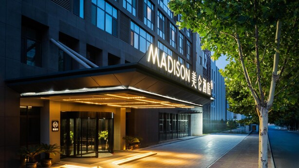 The exterior of the Madison Hotel with a modern facade, illuminated entrance, and a tree-lined pathway. - Madison Hotel Jinan Suncun Chunhui Road (Jinan)