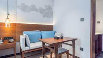 Ein modernes Zimmer mit einem Holztisch, einem blauen Sofa und einem kleinen Tisch mit Taschentüchern.