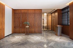 A modern lobby with wooden paneling, a herringbone floor, and a potted plant. - Madison Hotel Jinan Suncun Chunhui Road (Jinan)