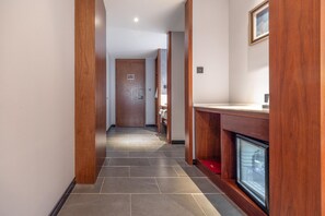 A hallway with wooden pillars, a tiled floor, a door at the end, and a small window with a red mat. - Madison Hotel Jinan Suncun Chunhui Road (Jinan)