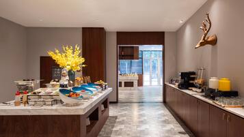 A modern kitchen with a marble countertop, wooden cabinets, and a decorative deer head on the wall.