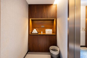 A hotel reception area with a wooden cabinet, a small basket, and a white storage box. - Madison Hotel Jinan Suncun Chunhui Road (Jinan)