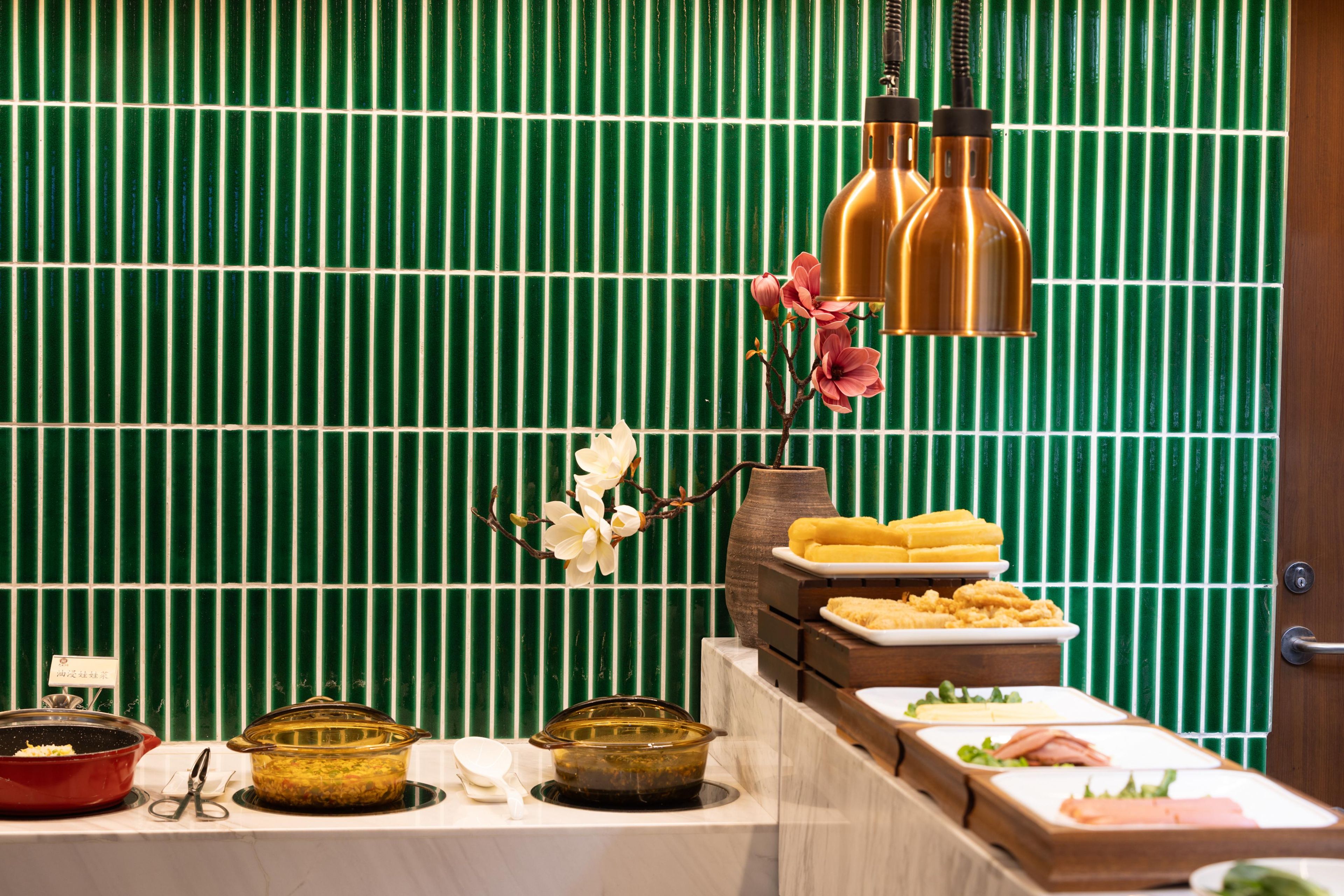 A buffet setup with various dishes and a decorative orchid.