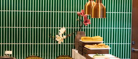 A buffet setup with various dishes and a decorative orchid.