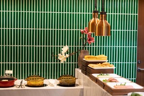 A buffet setup with various dishes and a decorative orchid. - Madison Hotel Jinan Suncun Chunhui Road (Jinan)