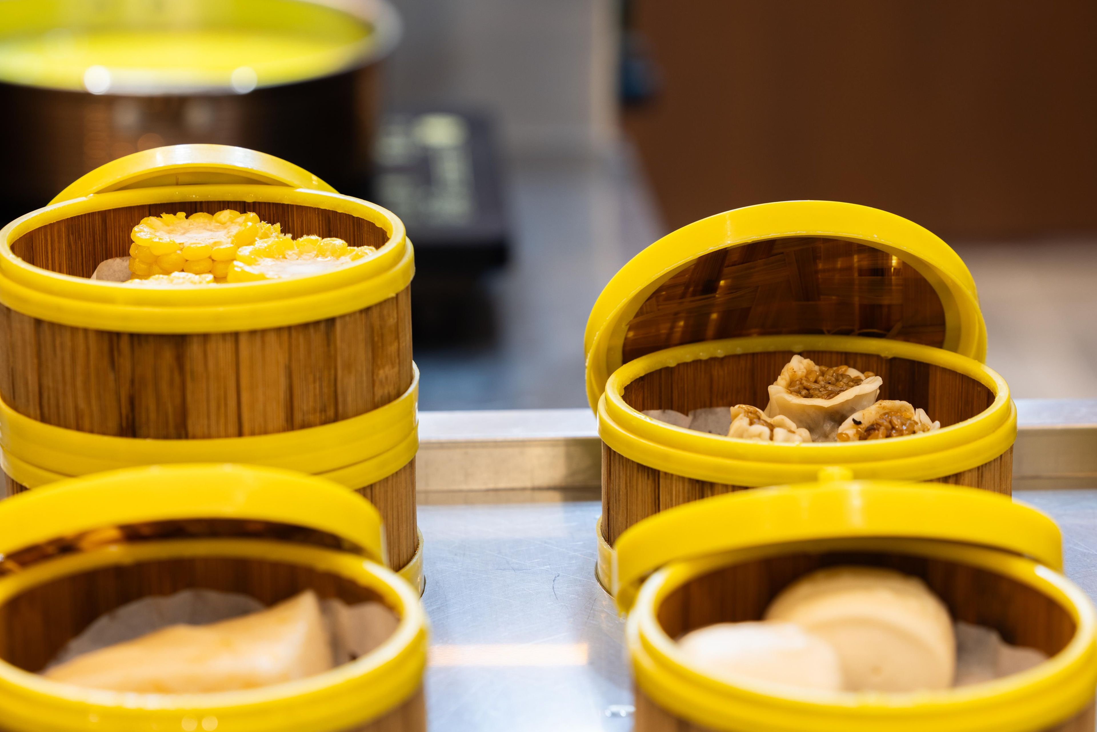 A row of wooden containers with yellow lids, likely used for storing food items.