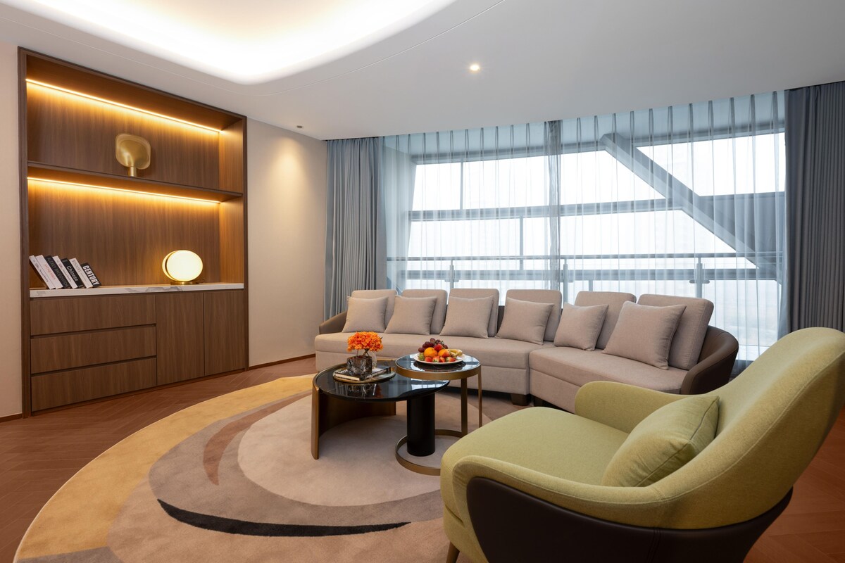 Una sala de estar moderna con un conjunto de sofá, una mesa de centro y una estantería.