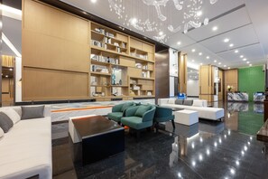 A modern lobby with a large bookshelf, seating area, and a reception desk. - Madison Hotel Binzhou Bincheng Wanda Plaza (Binzhou)