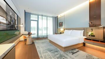 Ein modernes Hotelzimmer mit einem großen Bett, einem Schreibtisch und einem Fernseher.