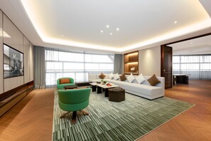 Una sala de estar moderna con un sofá, un sillón verde y una mesa de centro.