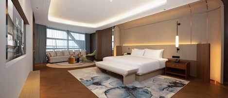 Una habitación de hotel moderna con una cama grande, un sofá, un escritorio y vistas a la ciudad.