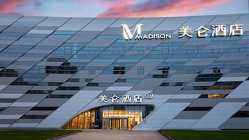 Un hotel moderno con una fachada geométrica distintiva e iluminación.