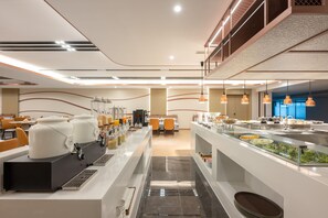 Un moderno comedor para desayuno con un sistema de buffet, que incluye dispensadores de comida y asientos.