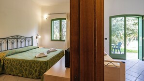A bedroom with a bed, bedside table, and a view of the outside through a door. - Borgo Primizia B3 Pool And Sea, Otranto, Italy (Otranto)