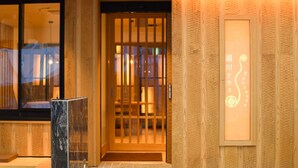A wooden exterior with a sliding door and a small entrance. - Yukawa Terrace (Kusatsu)