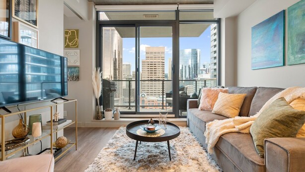 A modern living room with a large TV, a sofa, and a coffee table.
