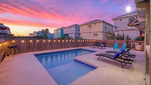 A backyard with a swimming pool, lounge chairs, and a wooden fence. - Sleeps 20! 2 Homes Near the Beach, Private Pools, Gameroom, Large Family Retreat (Port Aransas)