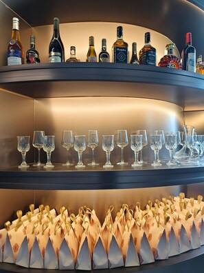Eine Bar mit mehreren Regalen voller Spirituosenflaschen und Gläsern.